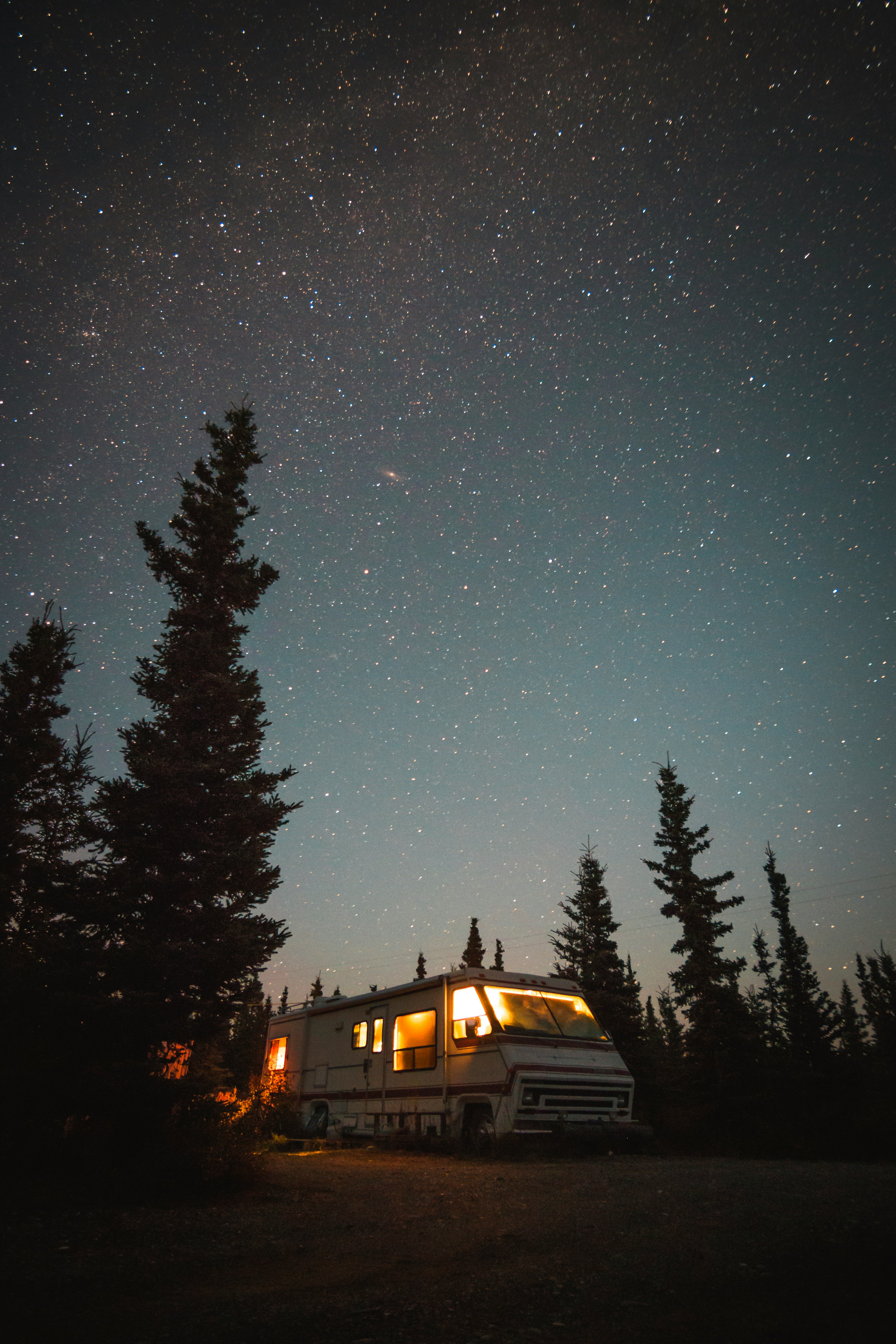 lighted white recreational vehicle into the woods